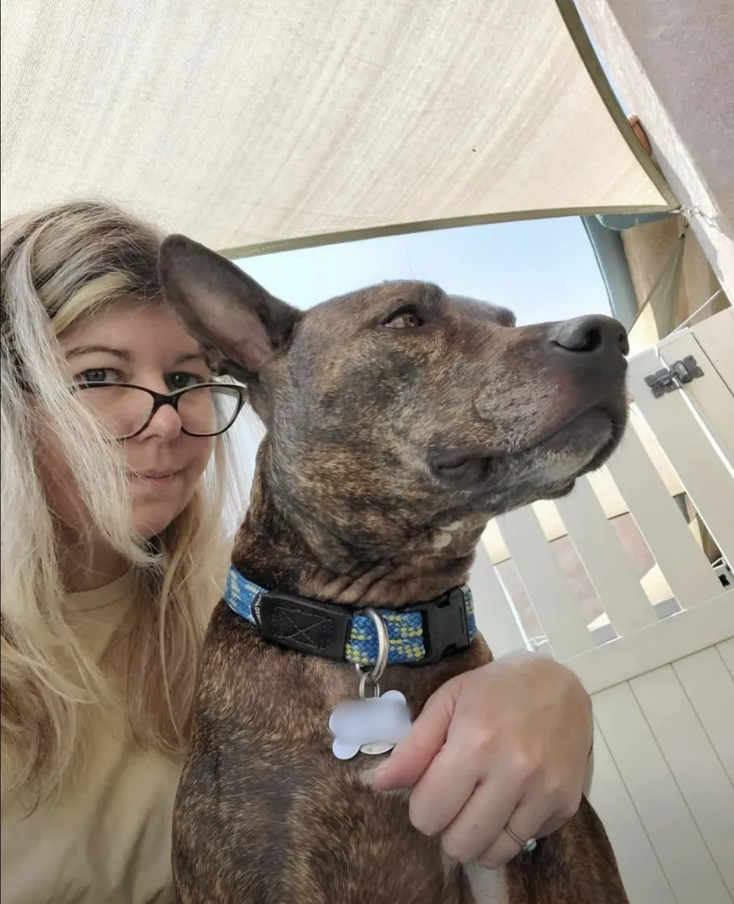 Sarah and a brindle pup posing in the shade